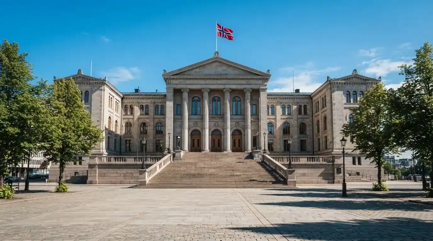 Fasade av en stor offentlig bygning i Oslo med brede trapper og et norsk flagg i vinden under klar himmel